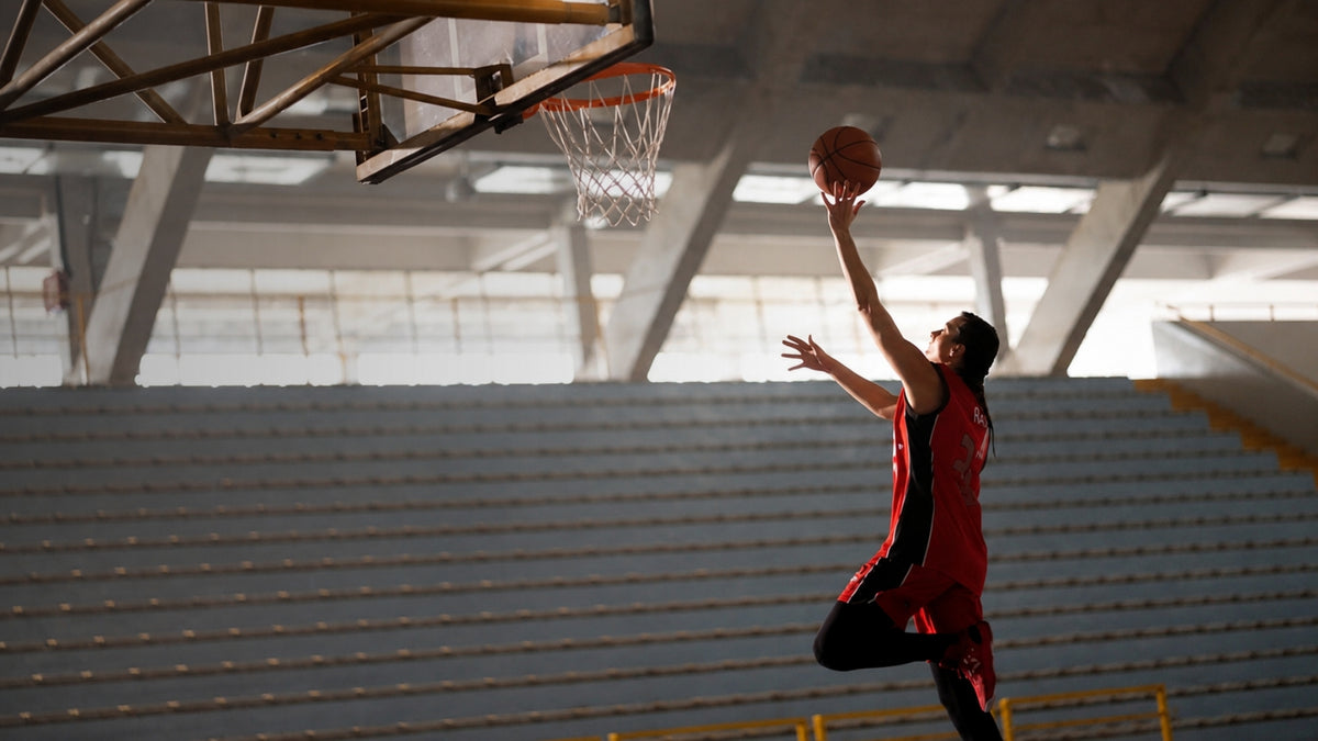 Athletic basketball player performing a high jump shot during game