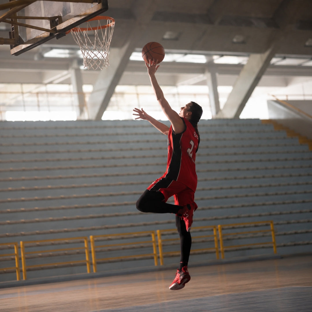 Athletic basketball player performing a high jump shot during game